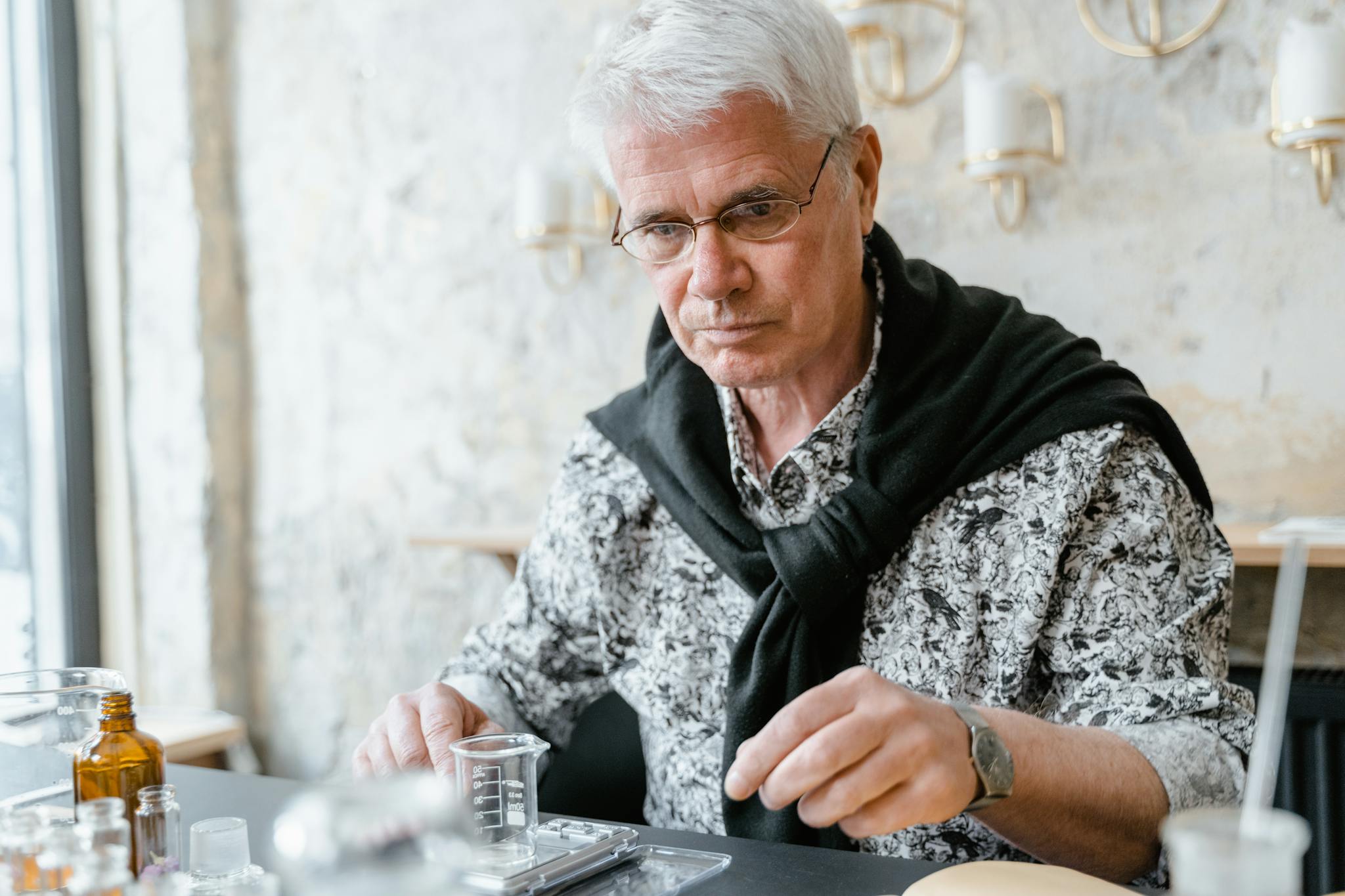 Elderly man experimenting with aromatherapy oils in a cozy room.